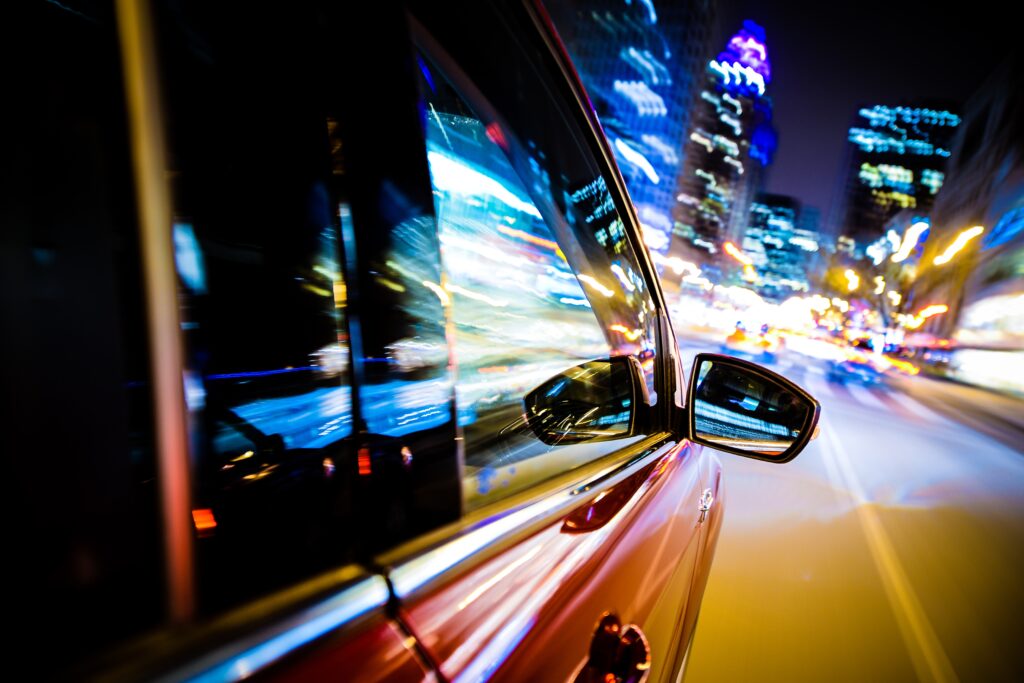 Driving Through City Lights. Car Side and Mirror View. 