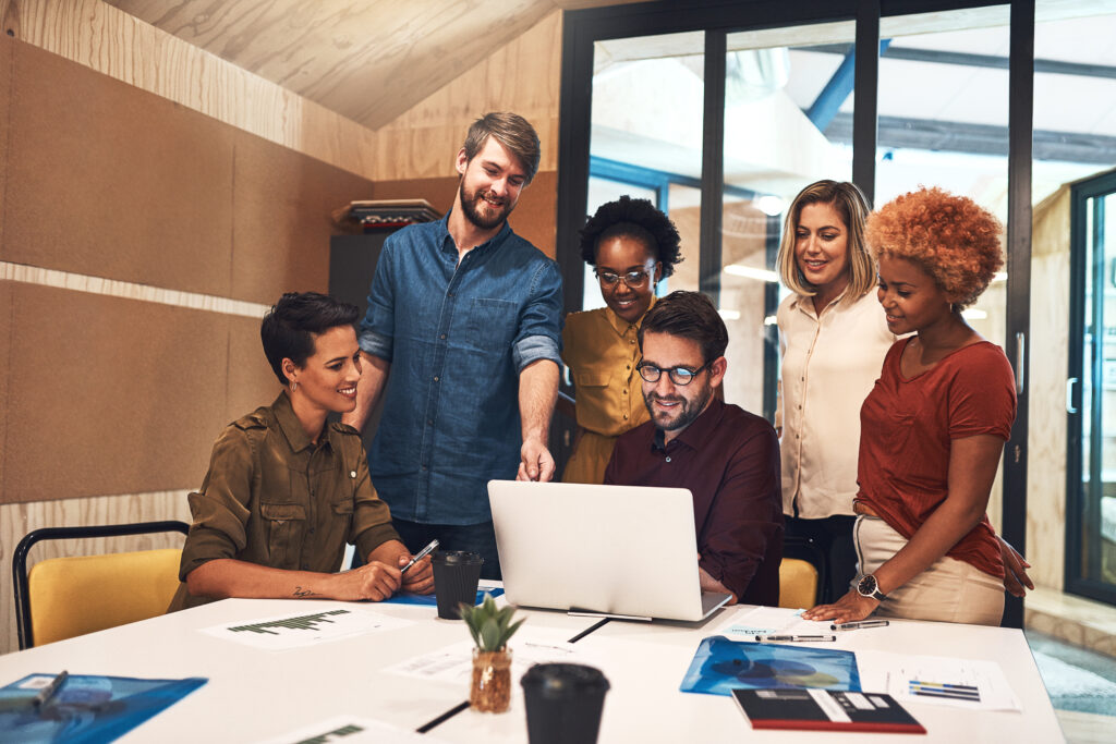 diverse group of businesspeople working together on a laptop in an office